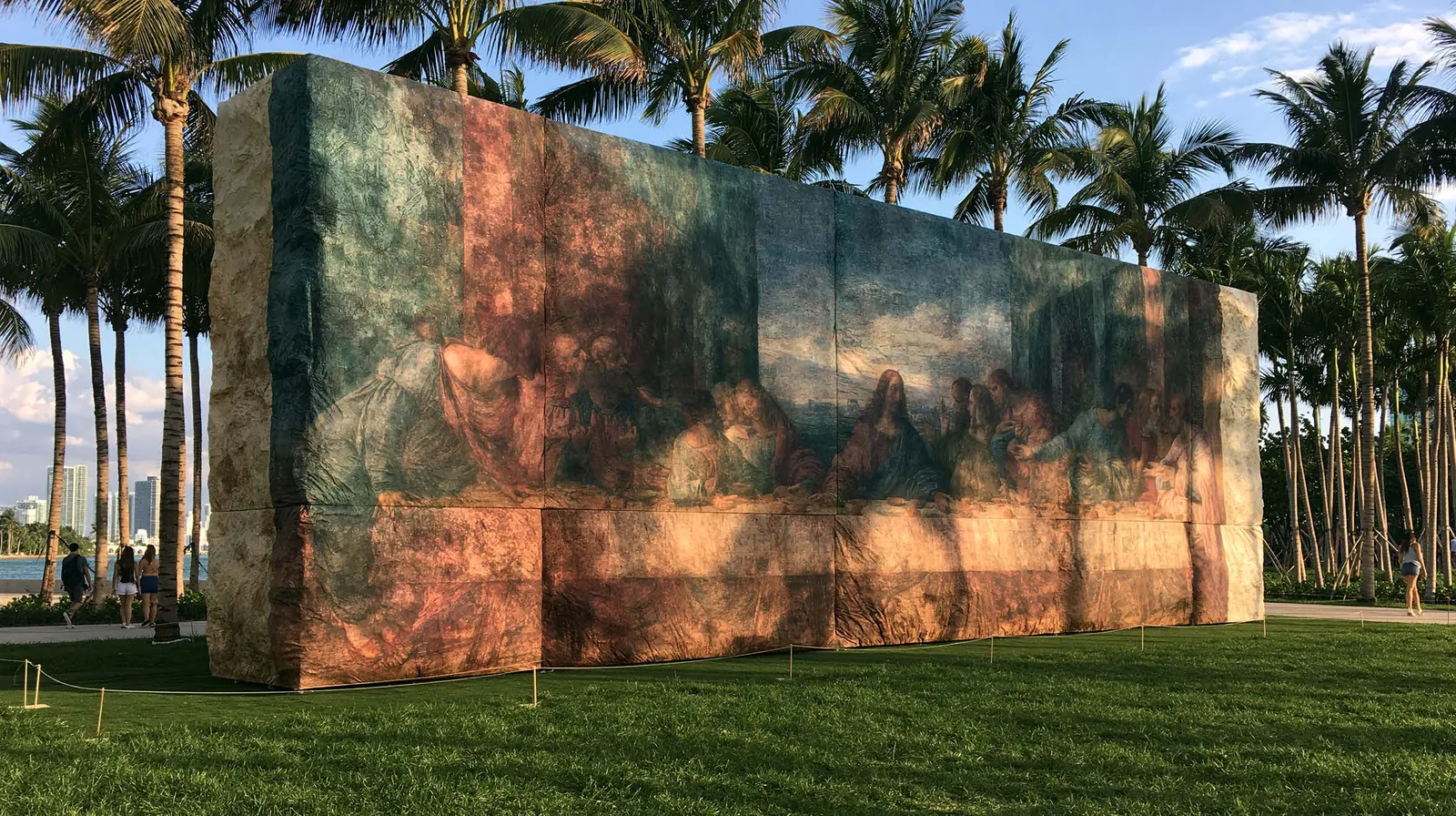A monumental Renaissance mural installation on a lawn among palms, Miami